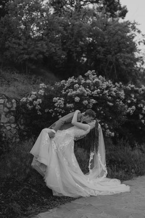 Dreamy black and white series showing a flowing white dress against garden roses and foliage.