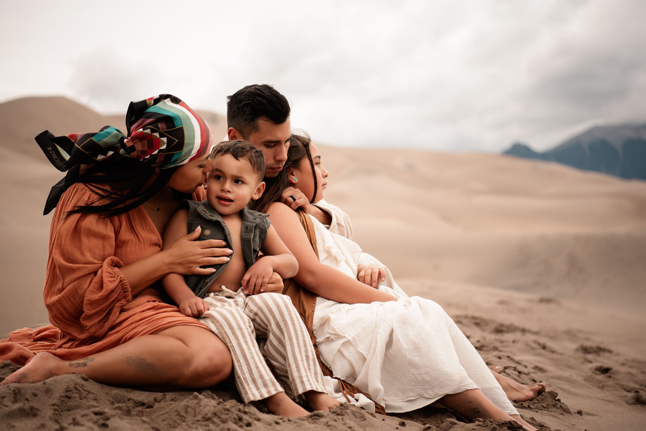 mother kissing son as family embraces in the the Great Sand Dunes Colorado.
