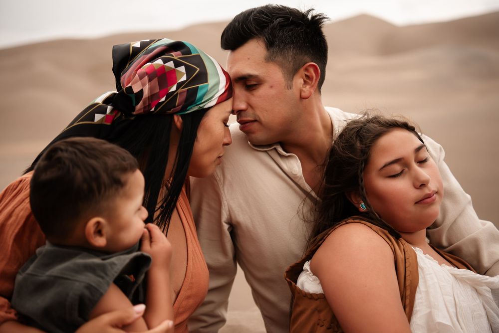 family embracing close up in sand dunes