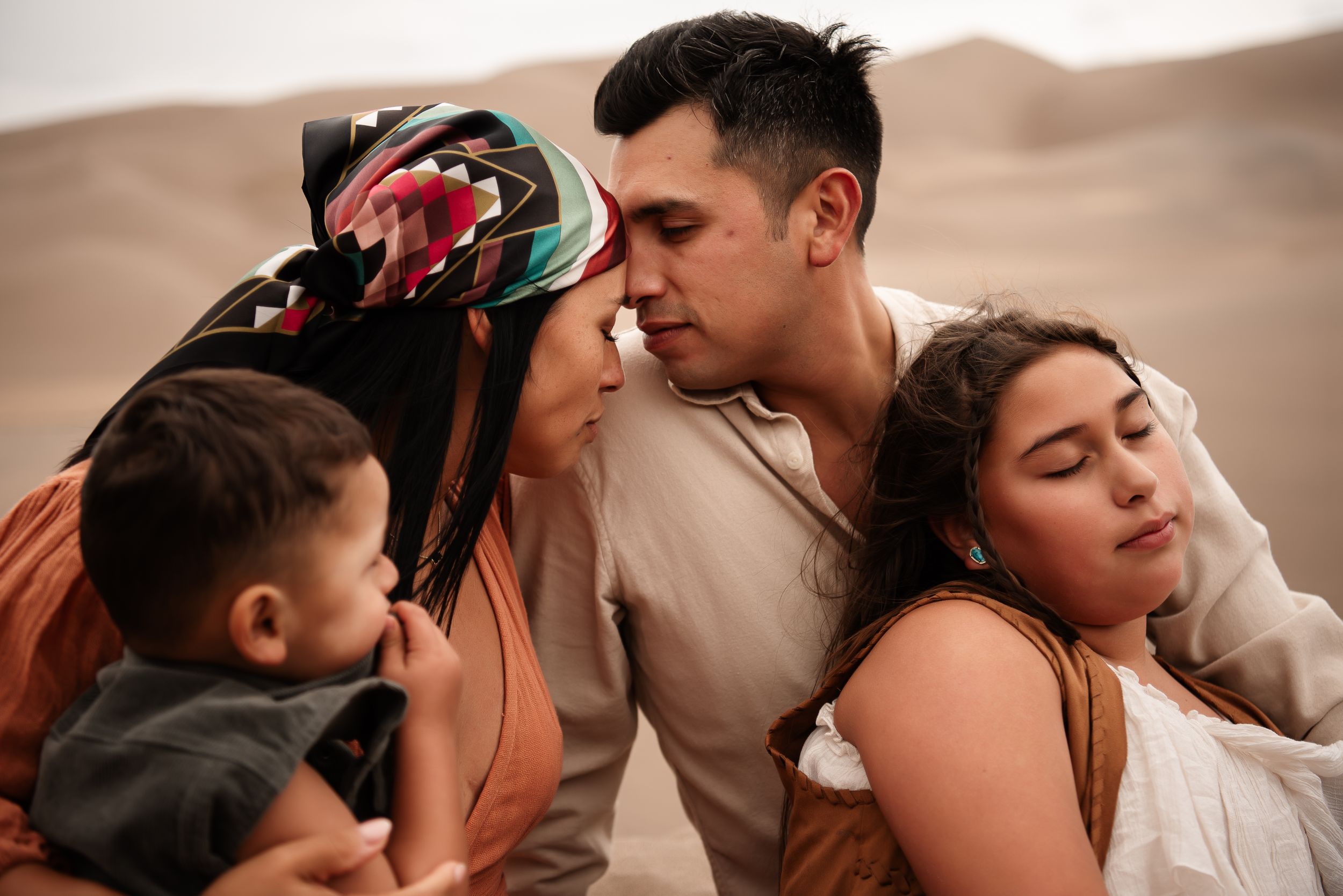 family embracing close up in sand dunes