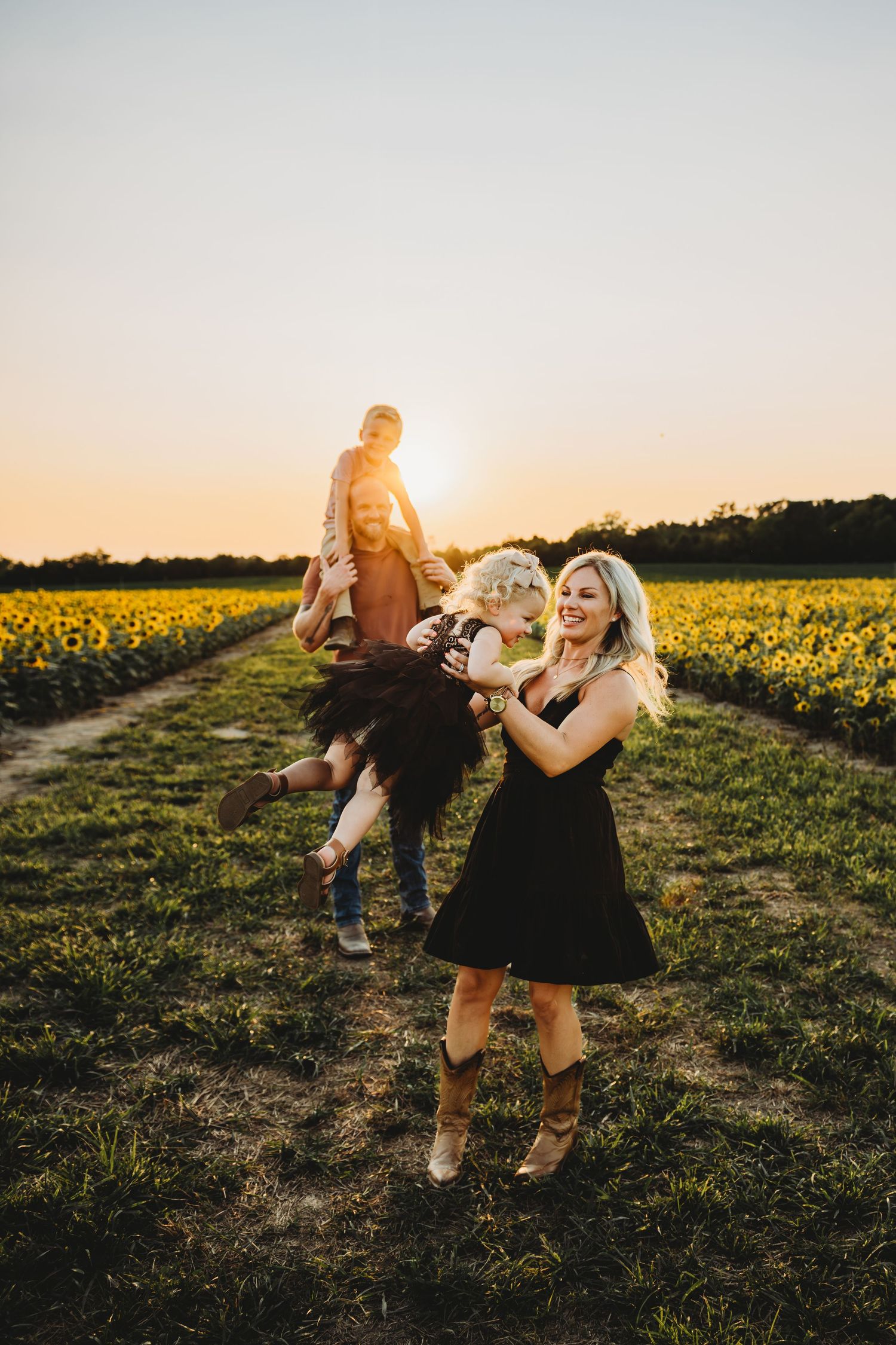 A person in a polka dot dress twirls in a field during golden hour sunset.