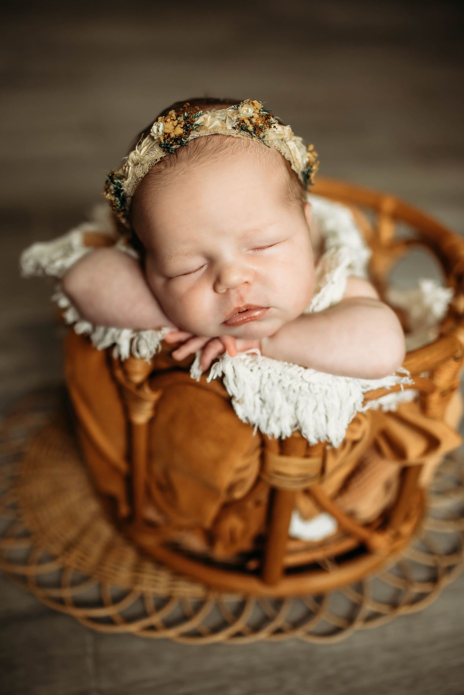 Posed newborn photography sleeping baby on hands with handmade headband in clients home