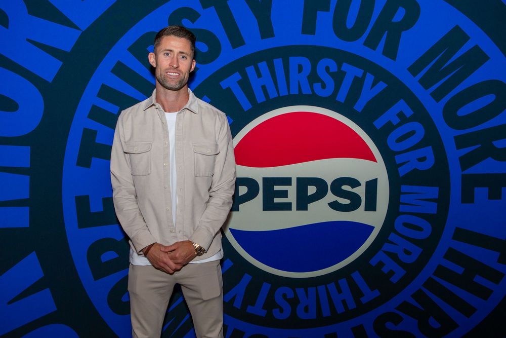 Pepsi branding display with blue and red corporate logo backdrop.