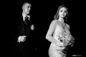 Black and white wedding photograph showing a couple in formal attire with bouquet and boutonniere.