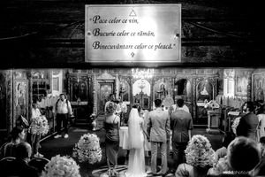 Black and white photo of a traditional Orthodox church wedding ceremony with attendees gathered before the iconostasis.