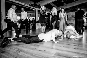 Wedding reception guests performing push-ups on the dance floor during a fun party moment.