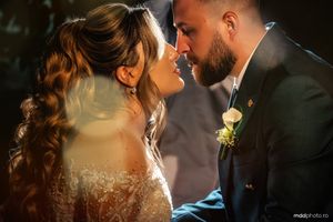 A romantic wedding portrait showing a couple in close embrace, with soft lighting and a delicate veil detail.