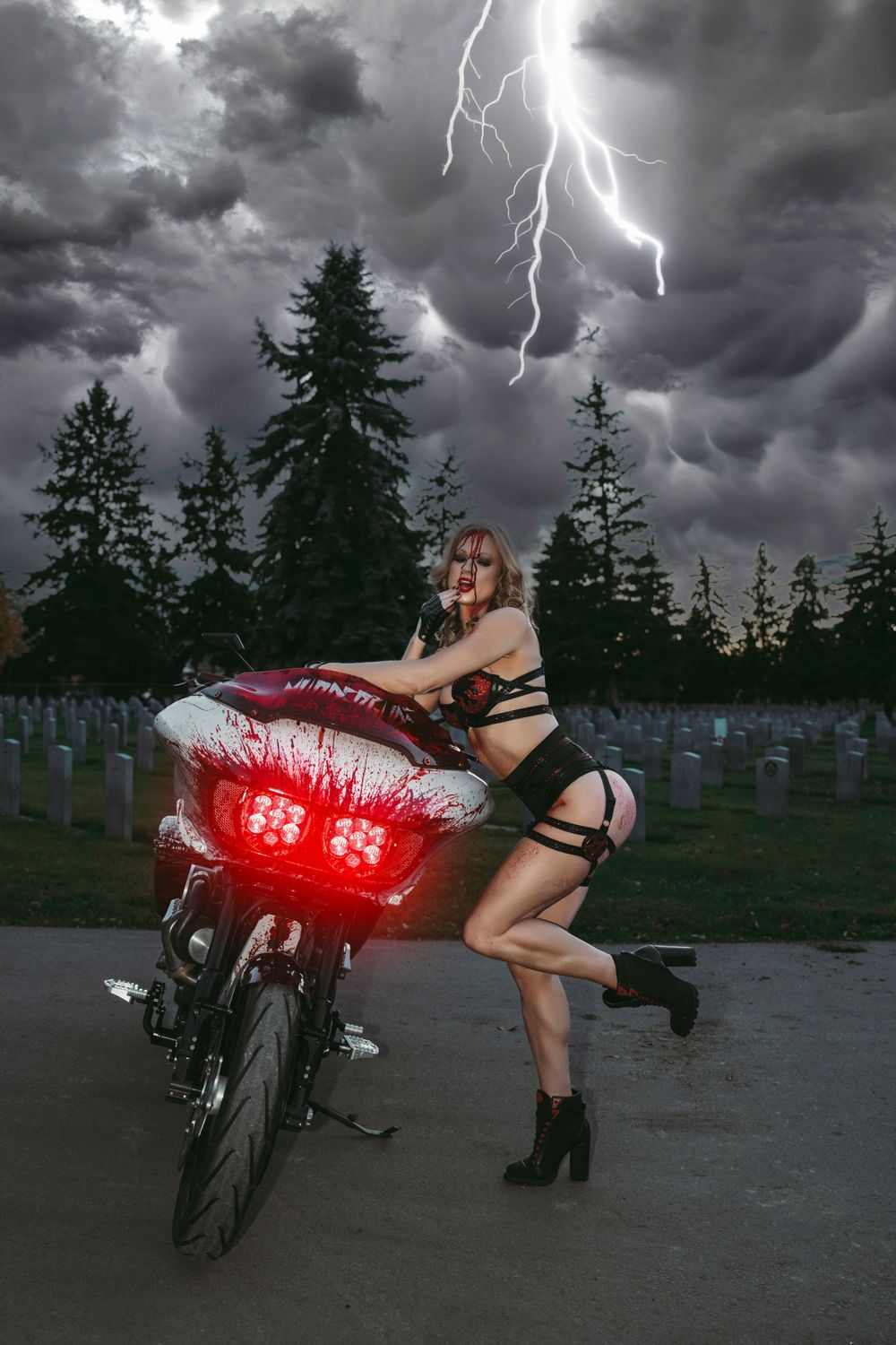 A motorcycle with glowing red lights parked in a stormy graveyard scene with lightning striking in the dark sky.