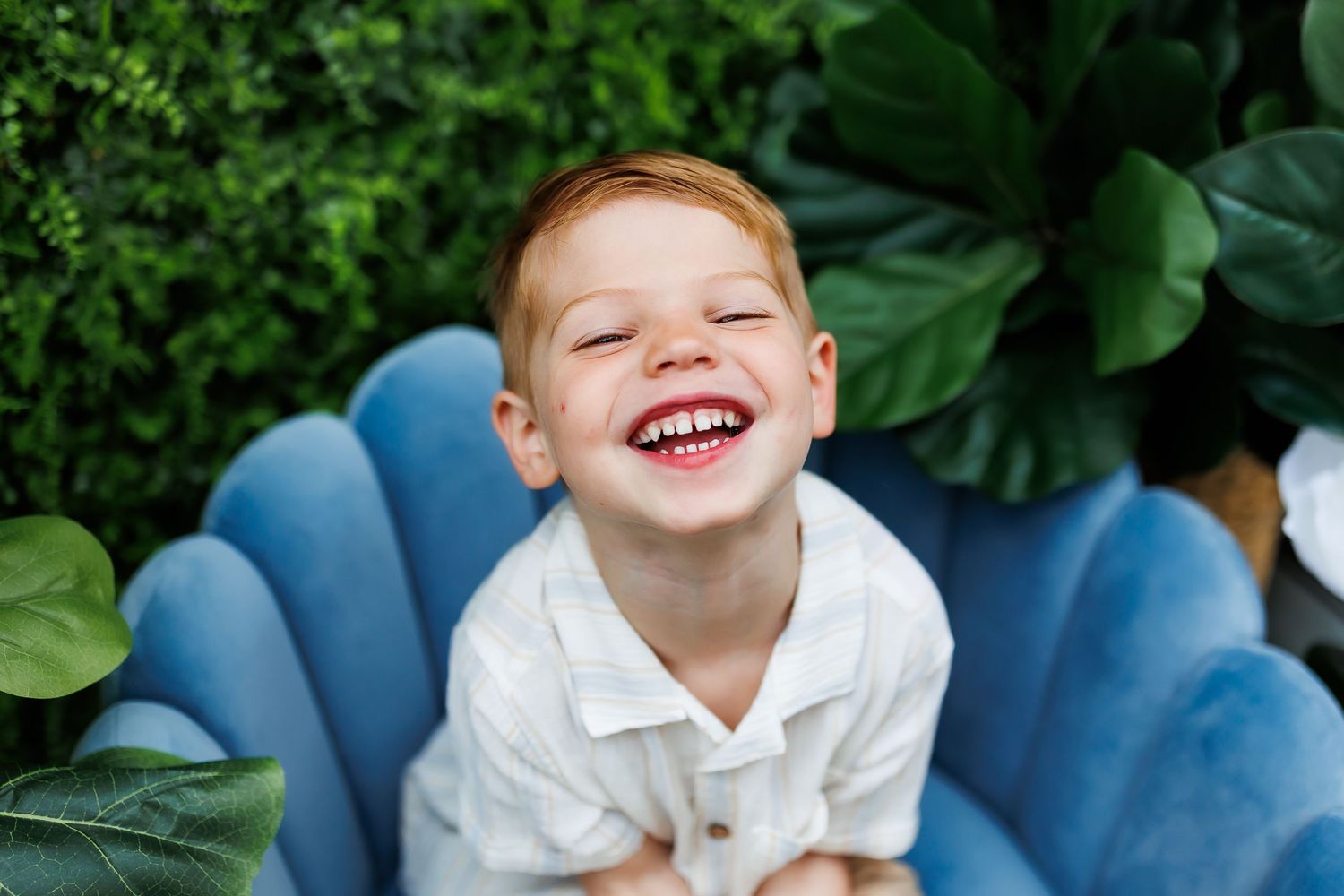 Child in patriotic outfit lying on vintage green couch.