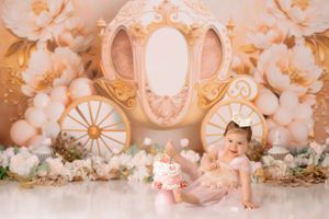 Fairytale carriage themed first birthday setup with golden accents and balloons.