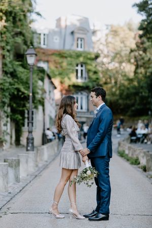 Couple enlacé dans une rue parisienne du quartier de Montmartre au coucher du soleil, ambiance douce et intime.