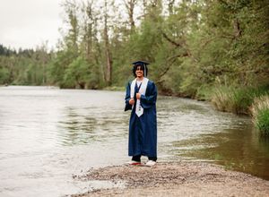 A series of graduation photos taken near a scenic river bank with trees in the background.