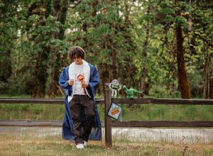 A panoramic view of a graduation photo session setup in a natural wooded setting with park benches.