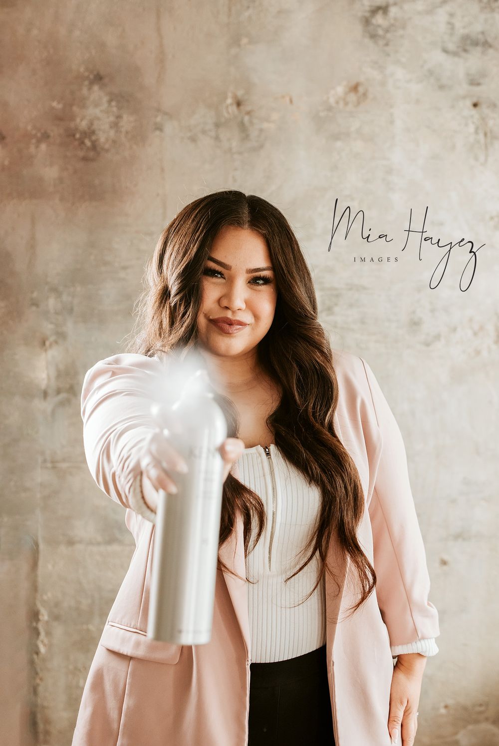 Fashion portrait series with model wearing pink blazer and white top against concrete backdrop.