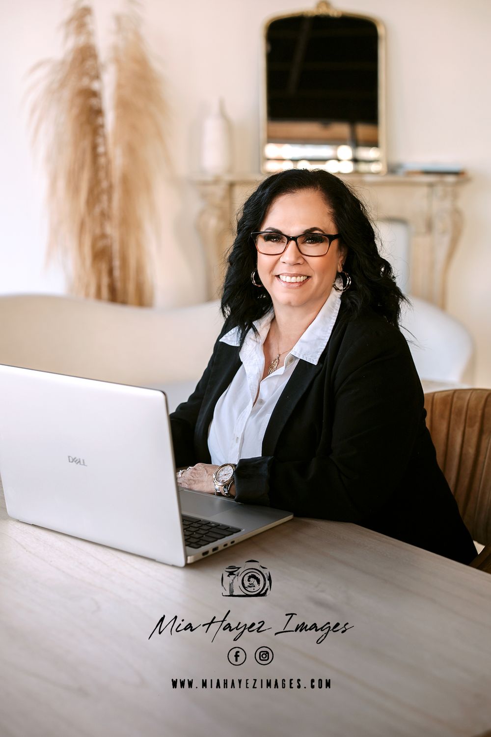 Professional business photography session at modern desk with laptop and natural lighting.