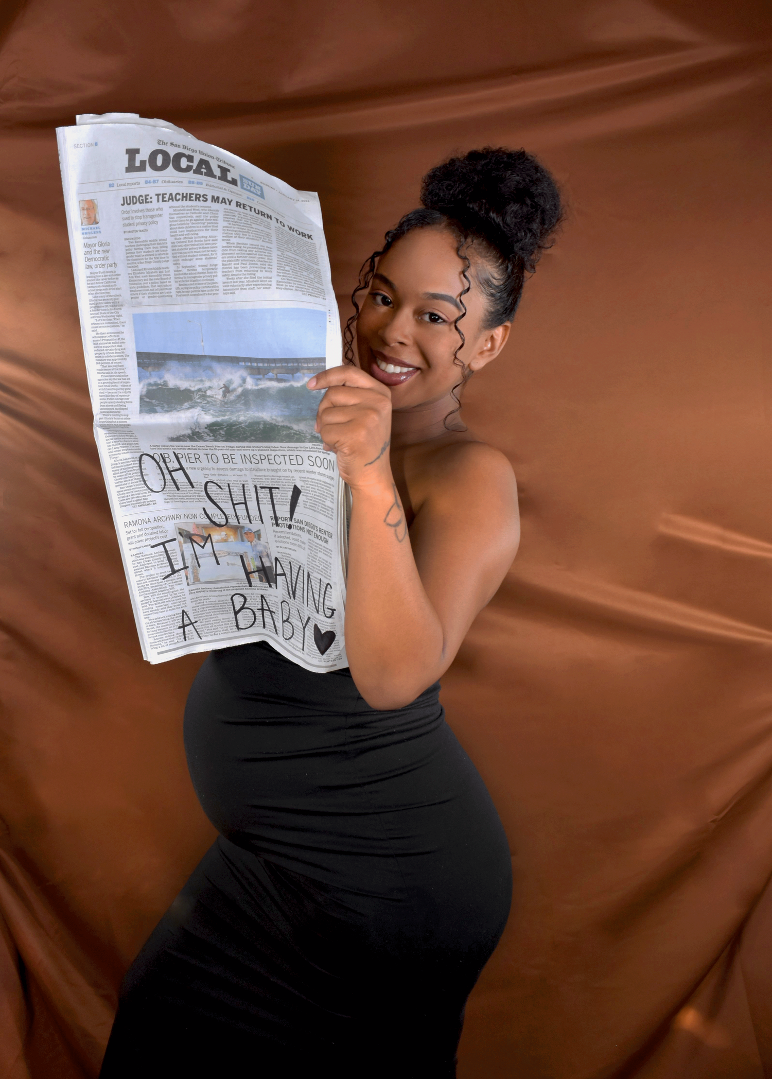 model holding newspaper announcing pregnancy