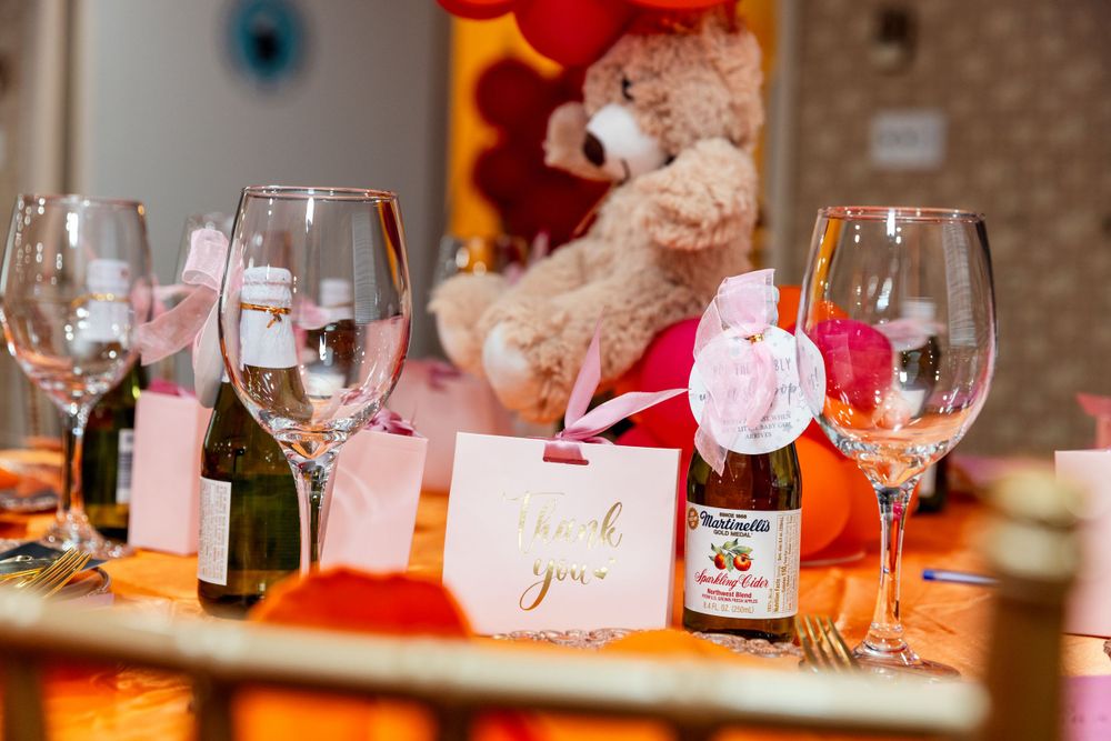 Close up of elegant table settings with wine glasses and teddy bear decorations.