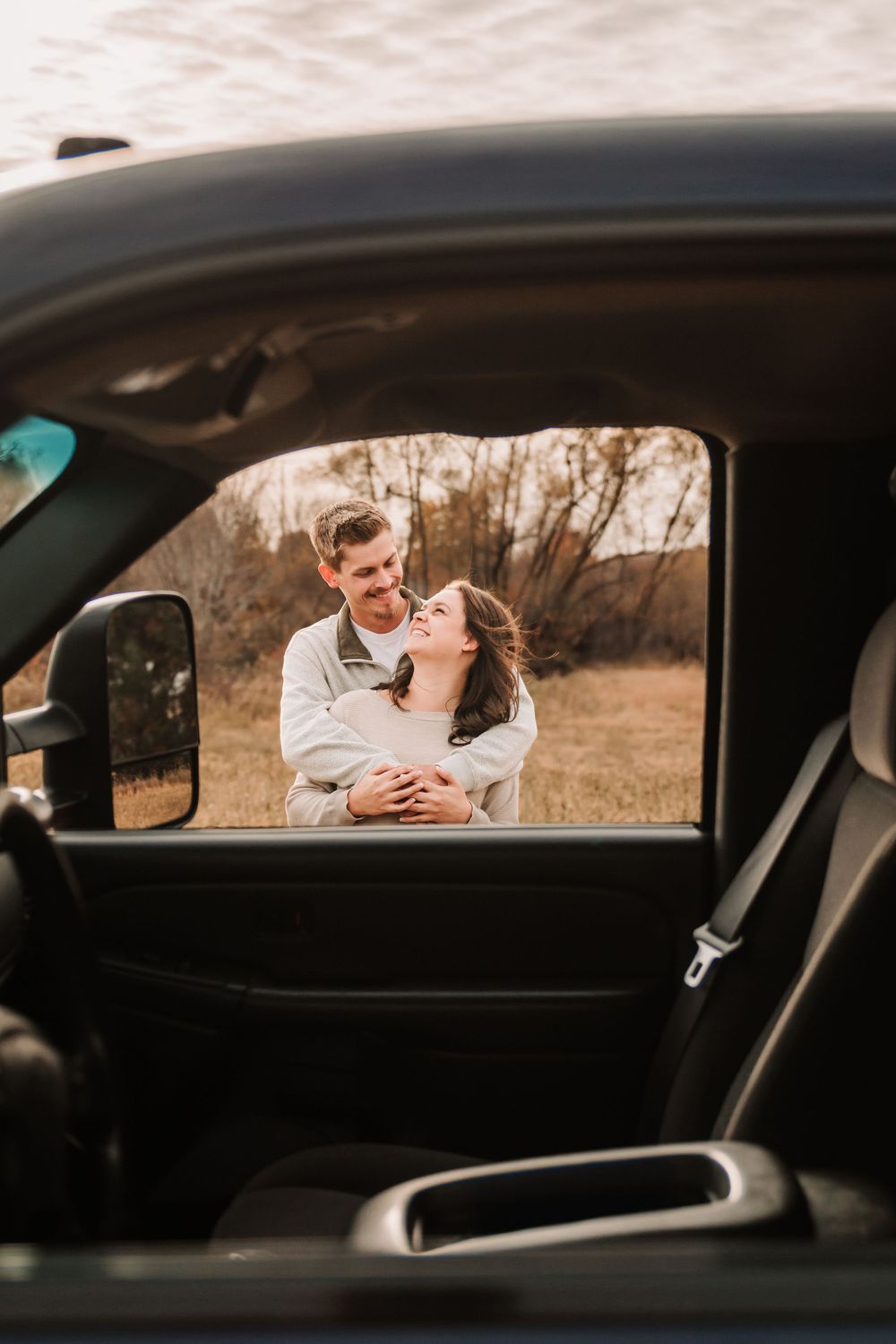 A romantic scene viewed through a car window frame at sunset.