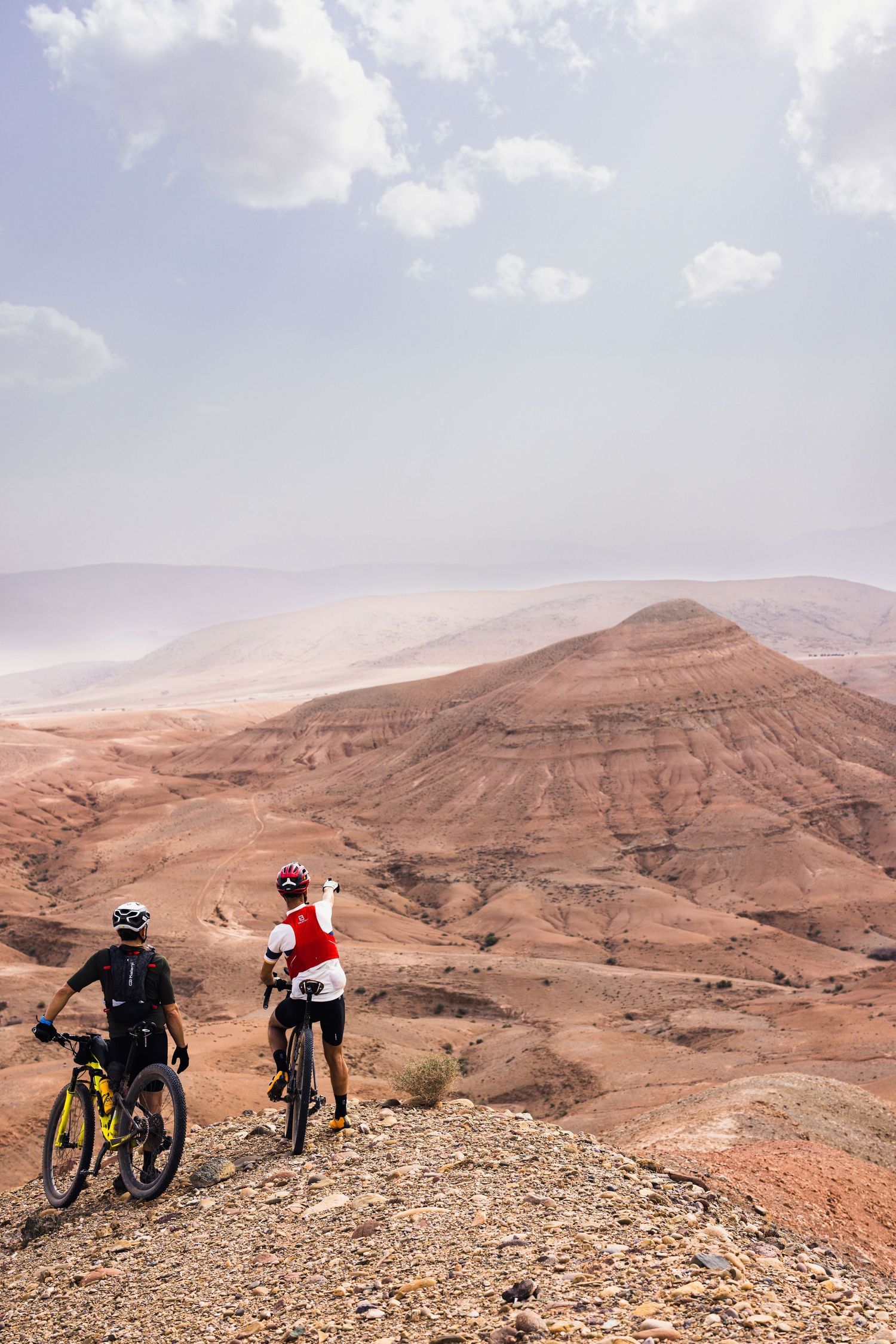 deux sportifs regardant la montagne au loin à dans le désert d’Agafay au Maroc, photo magnifique sous un ciel nuageux