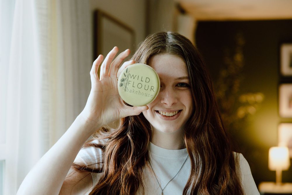 Baker holding a jar labeled 'flour' in a bright, modern kitchen setting.