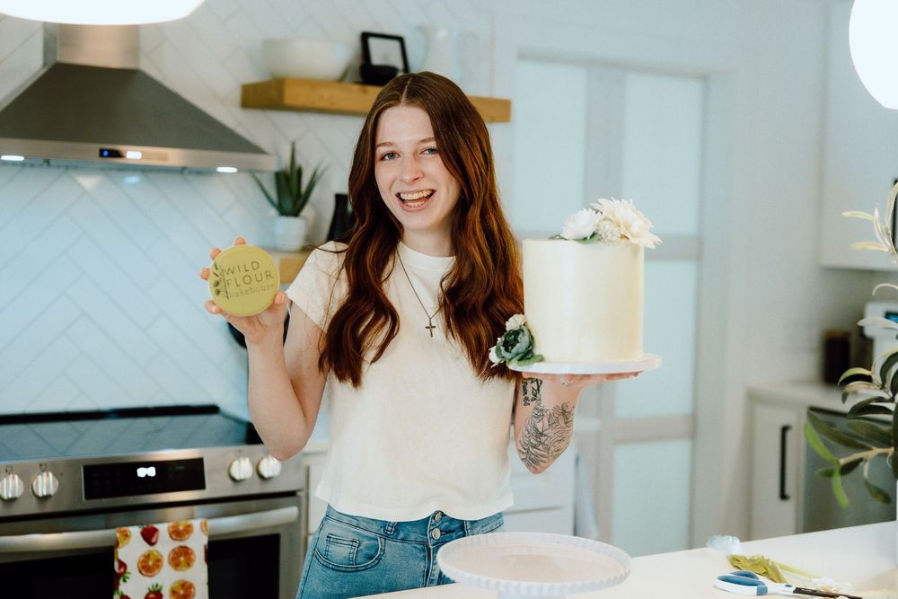 Modern kitchen scene with baking supplies and a decorated cake on display.