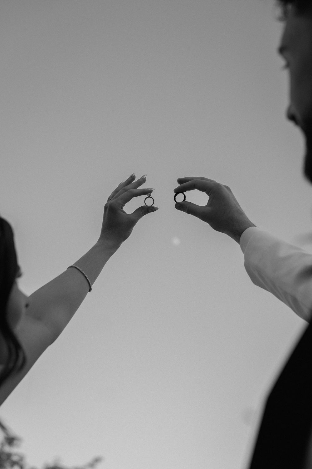 A sequence of black and white silhouettes showing hands reaching upward against a light background.