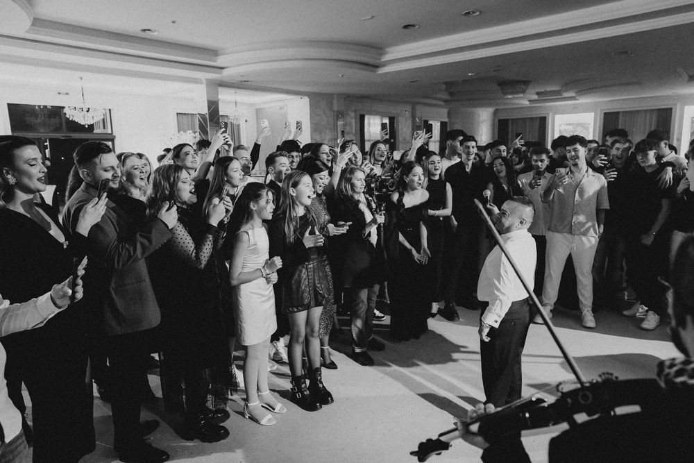 Wide angle shot of a crowded indoor event space with performers and guests.