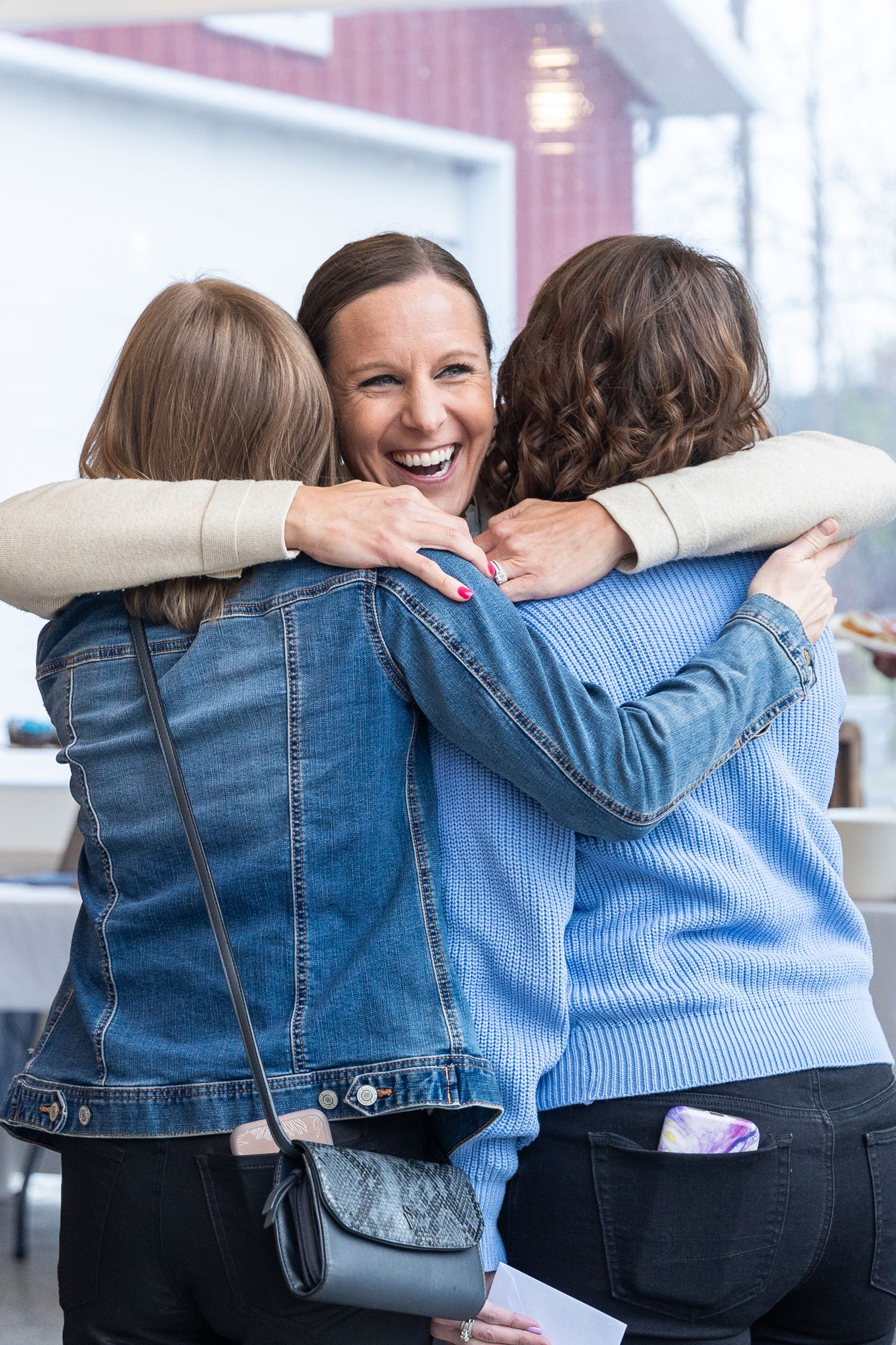 Group of friends hugging in denim jackets showing unity and friendship.