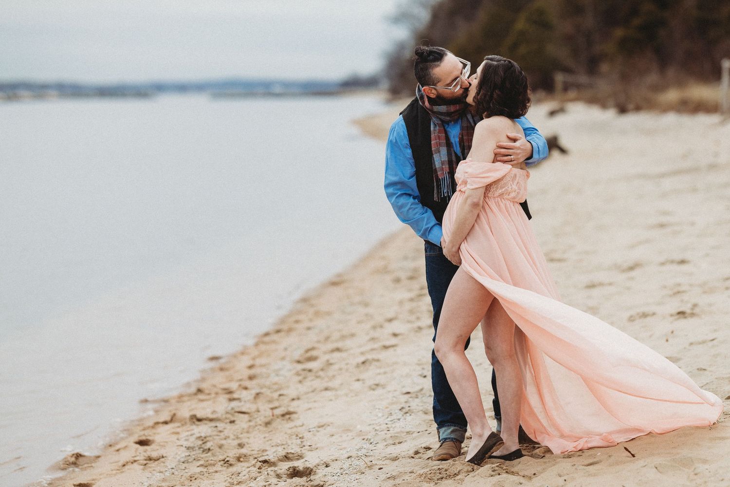 Romantic maternity beach photoshoot series with flowing pink dress on sandy shoreline. Annapolis maternity photographer. Edgewater Maryland