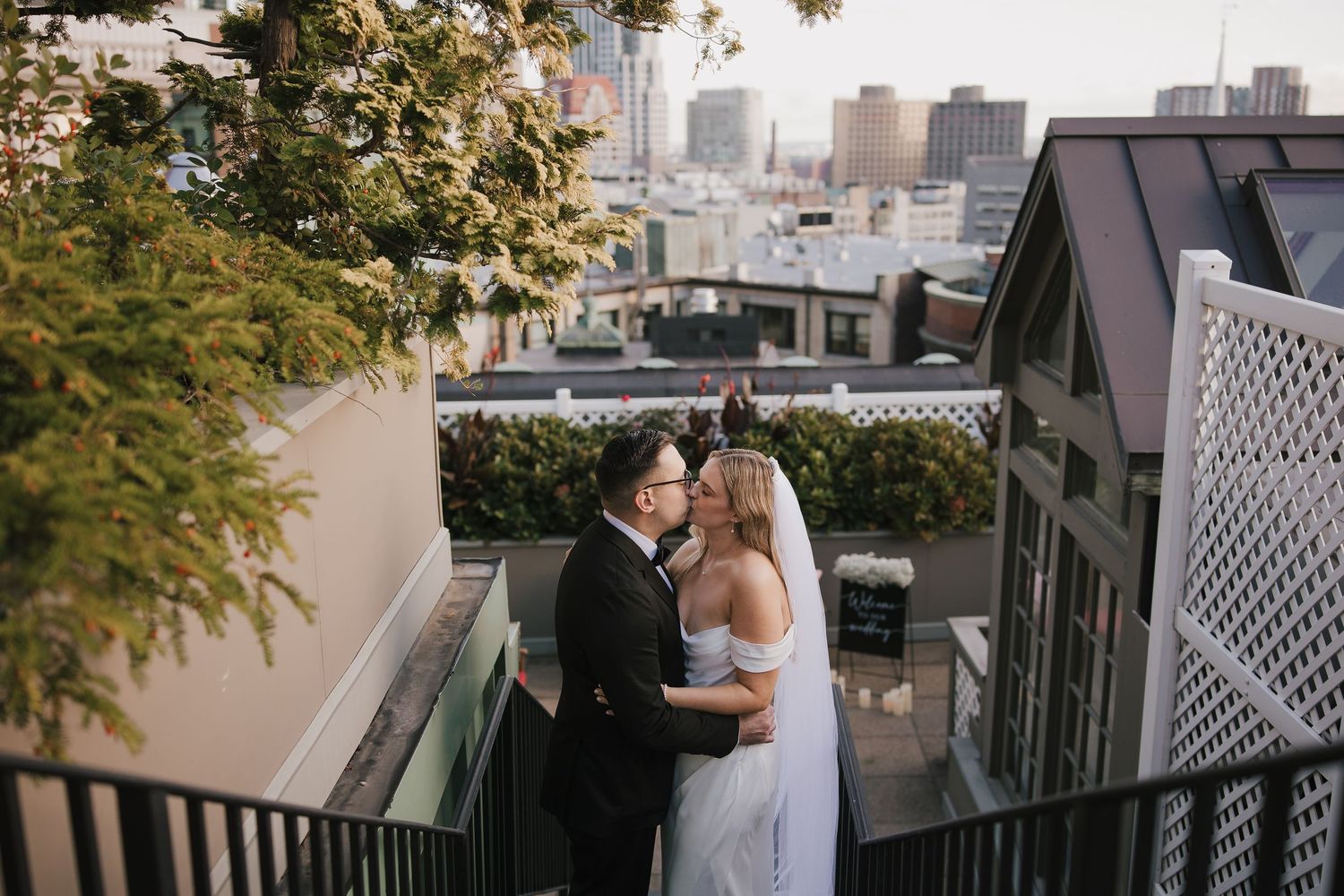 A wedding ceremony in progress on a grassy field with guests seated on wooden chairs.