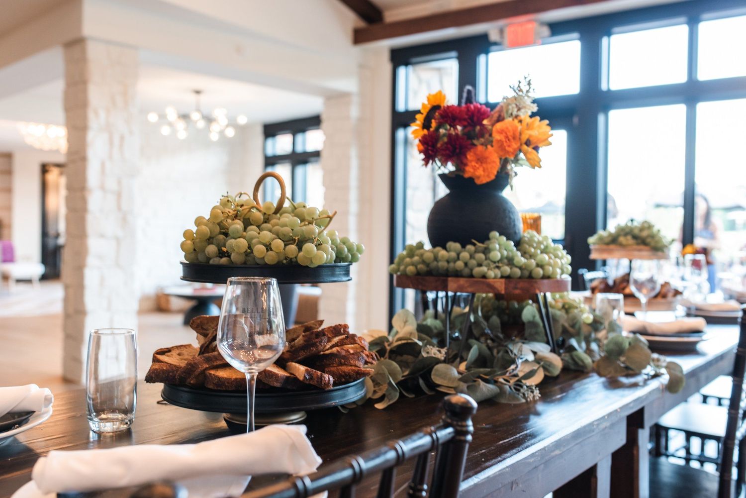 Elegant buffet table display with tiered serving platters of appetizers and floral centerpieces.