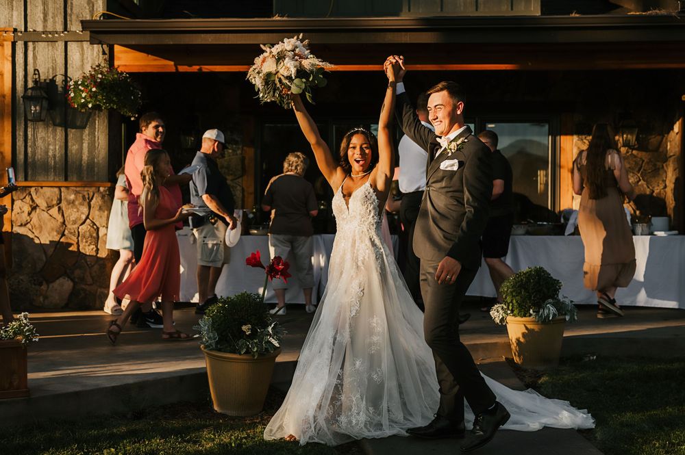 Wedding party celebrates and dances during sunset at an outdoor reception venue.