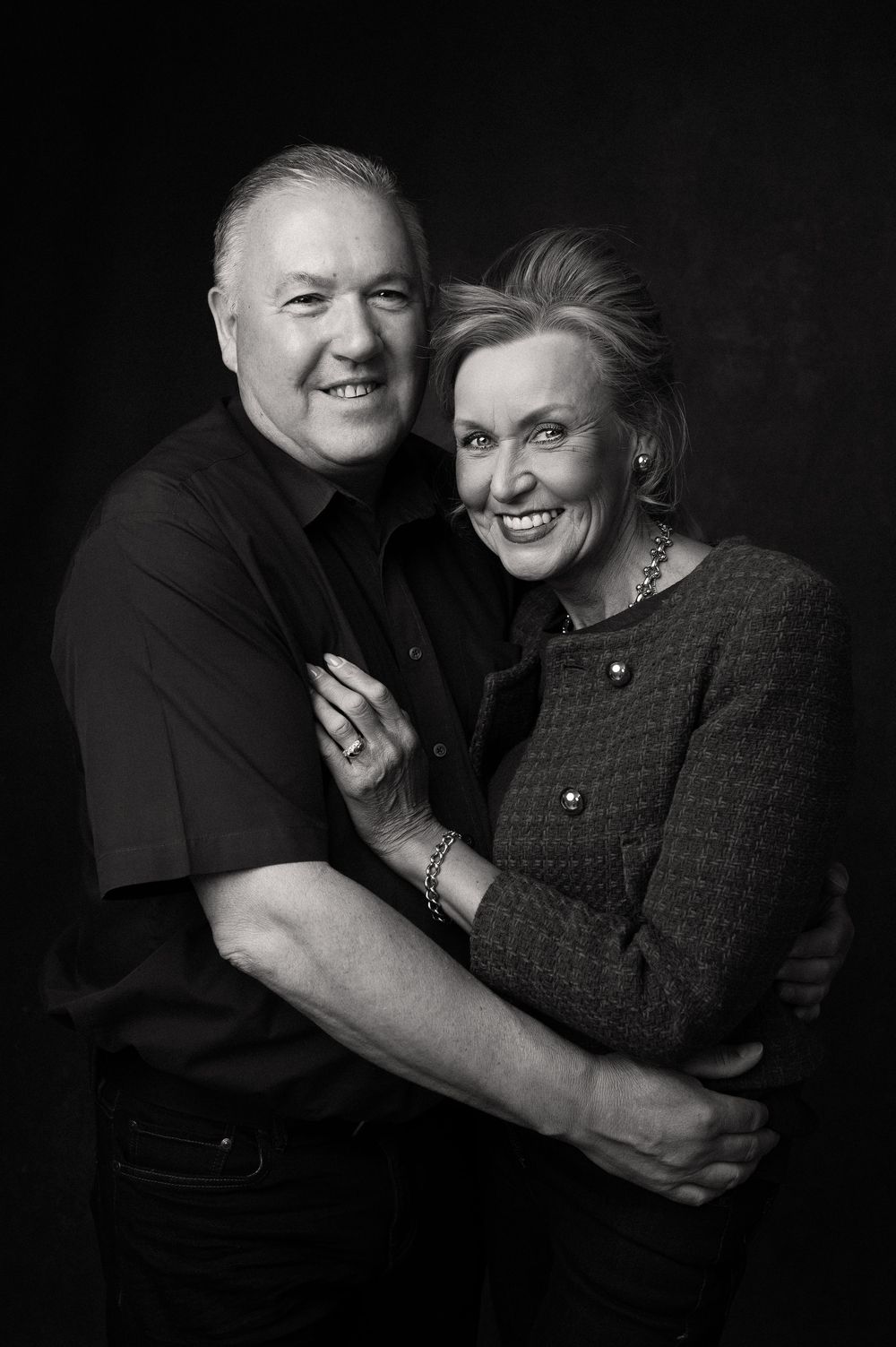 Black and white portrait of a happy mature couple embracing and sharing a joyful candid moment together.