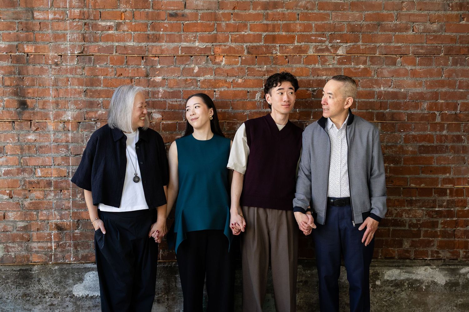Group portrait against rustic brick wall background.