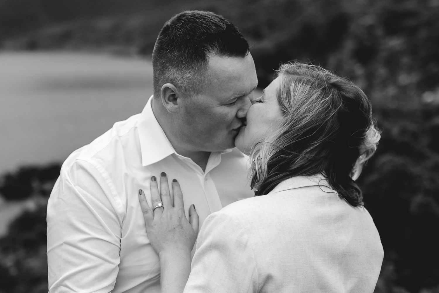 Intimate moment between couple with foggy mountain landscape behind them.