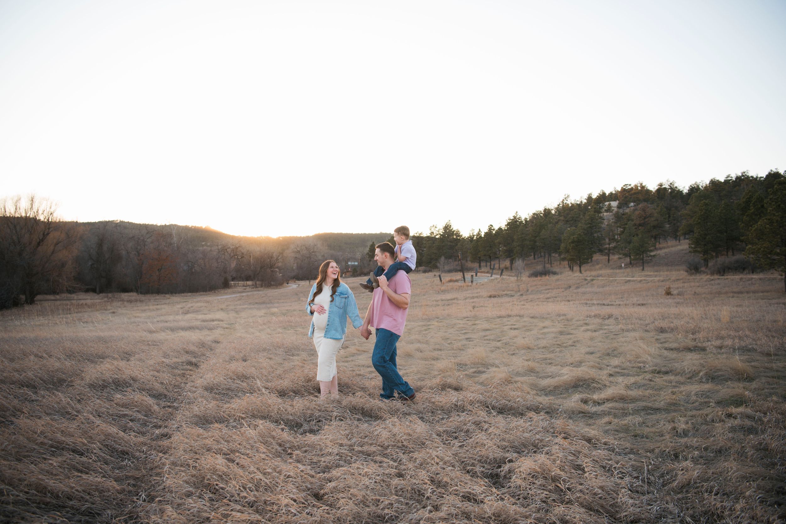 Couple walking together in a desert landscape during golden hour sunset.
