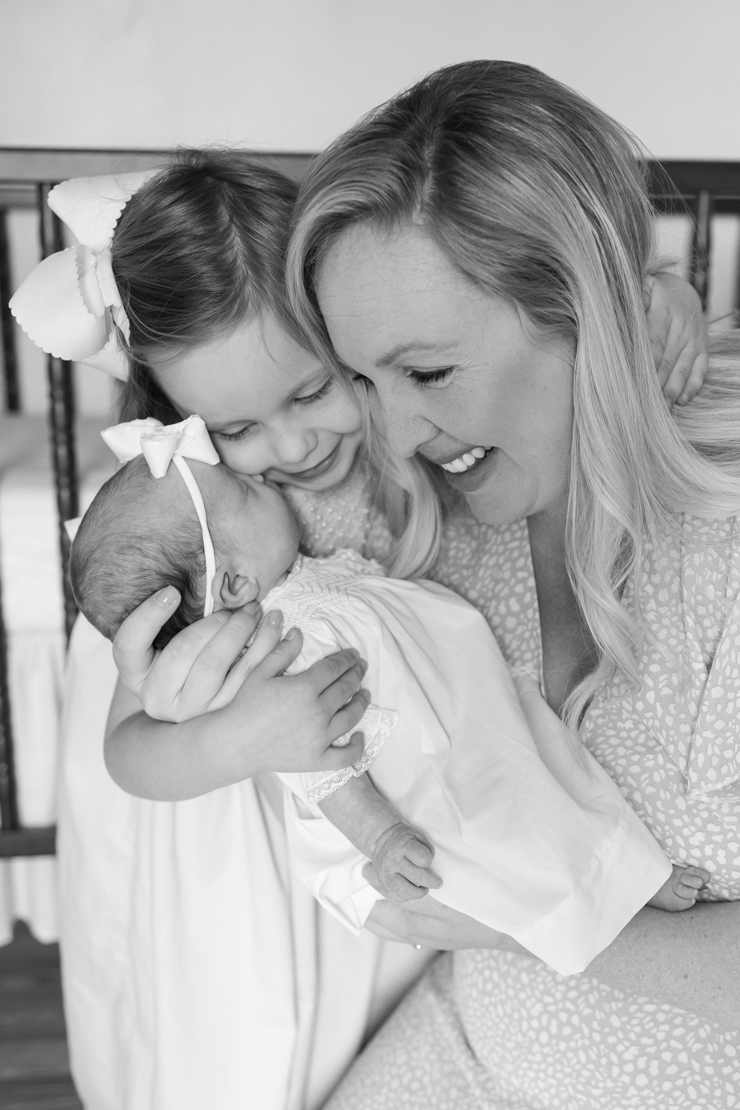 A series of tender black and white photos showing a mother lovingly embracing and snuggling with a newborn baby.