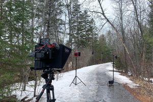Professional camera setup in snowy winter forest setting.