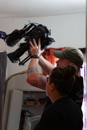 Camera operators positioning professional video equipment during indoor film production.