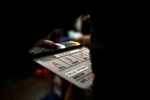 Close-up shot of film production slate or clapperboard in dark lighting.