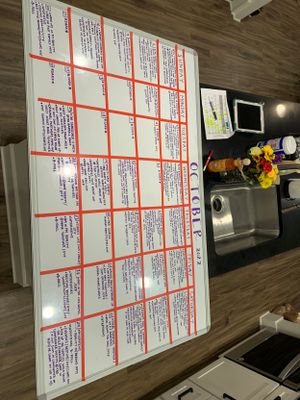 Production schedule board with red grid lines on a wooden desk.