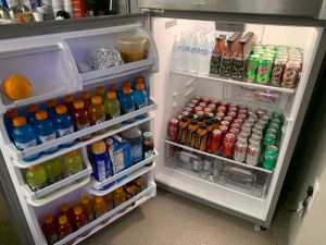 Refrigerator stocked full with various colorful beverages and drinks.