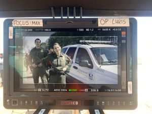 Production monitor showing footage from a law enforcement scene.