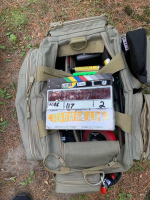 Professional camera equipment bag filled with production gear and slate visible from above.
