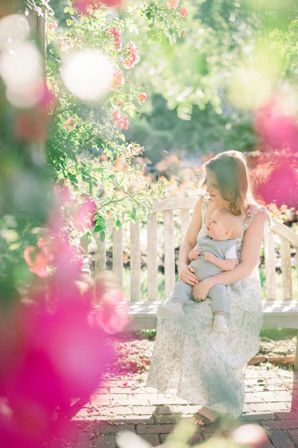 Mother sitting in garden during a maternity session  at Bon Air Rose Garden in Arlington Virginia