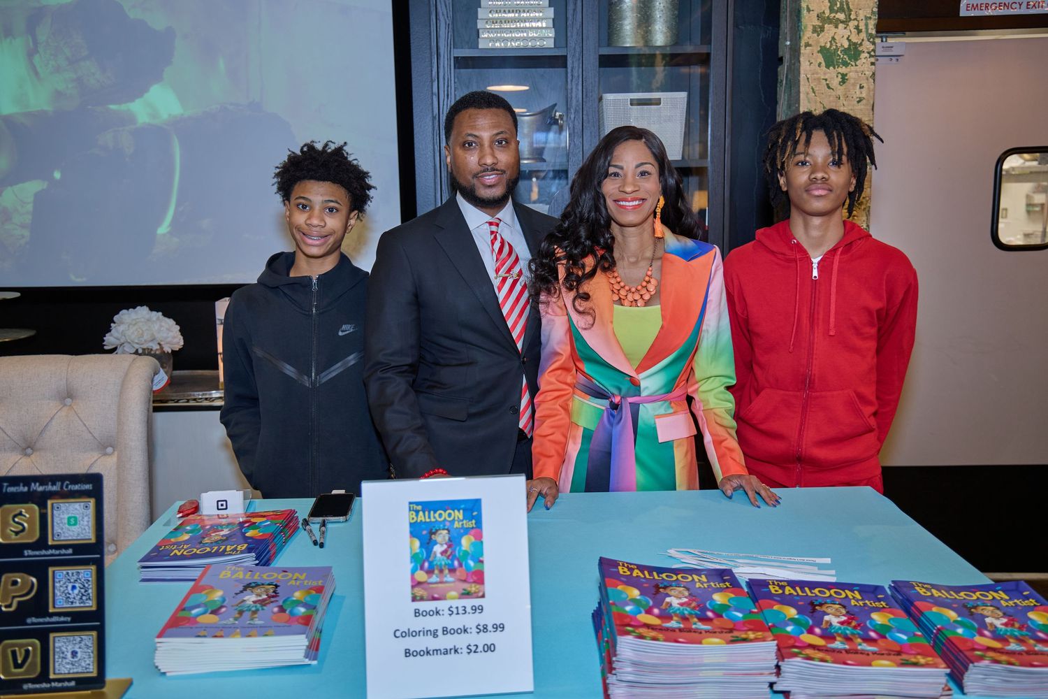 Book signing event with displays and promotional materials on table.