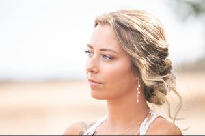 An elegant side profile portrait with sparkly earrings and upswept hairstyle.
