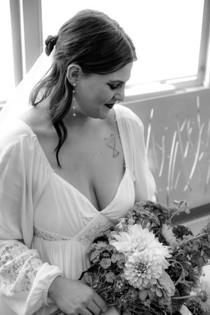 Black and white portrait of bride holding floral bouquet.