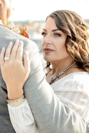 A close-up bridal portrait showing elegant jewelry and romantic waves hairstyle.