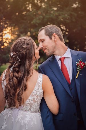 Romantic wedding portrait of couple in formal attire during golden hour.